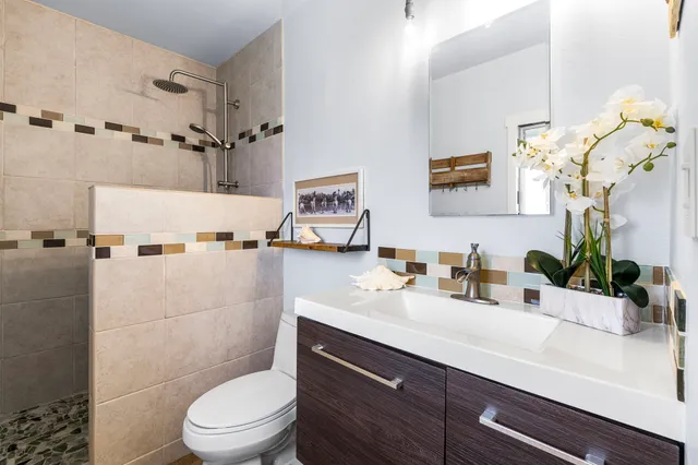 a bathroom with a sink a toilet and shower