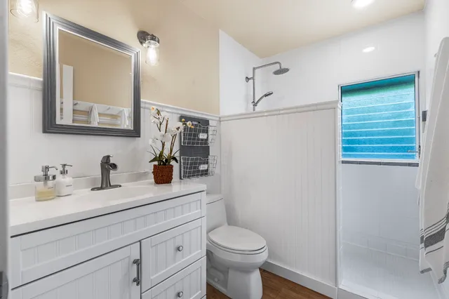 a bathroom with a granite countertop toilet sink and mirror