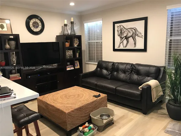 a living room with furniture a flat screen tv and a wall
