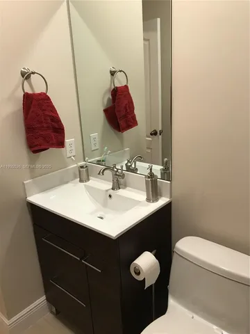 a bathroom with a sink vanity and a toilet