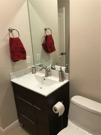 a bathroom with a sink vanity and a toilet