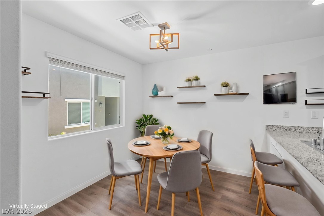 12367 Indigo Montage Road, Unit 3 Las Vegas, NV 89183 - Photo 8 of 33 This bright dining area features an open concept layout, wood flooring, and a large window.
