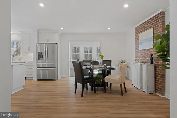 a dining room with furniture potted plants and wooden floor