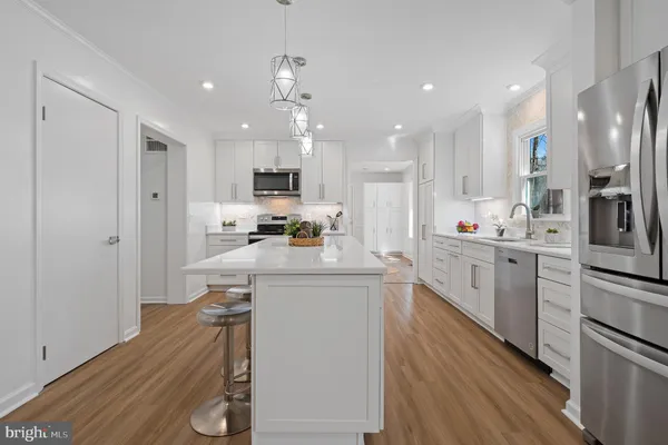 a kitchen with kitchen island granite countertop a sink and cabinets