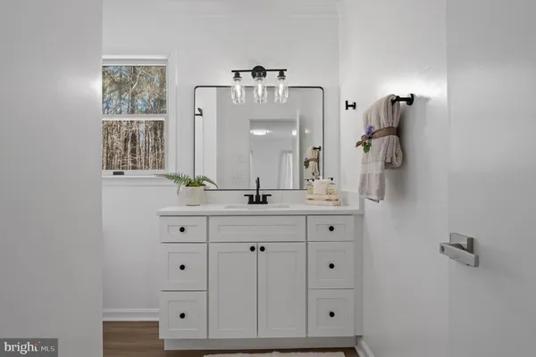 a bathroom with a sink vanity and mirror