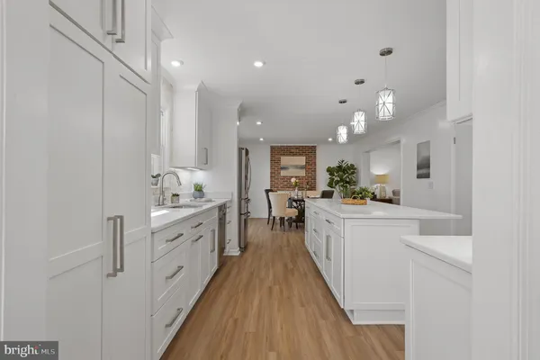 a kitchen with stainless steel appliances granite countertop a sink a stove a refrigerator a dining table and chairs