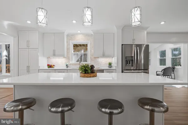 a kitchen with white cabinets and sink