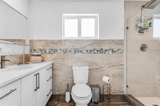a bathroom with a granite countertop toilet sink and mirror