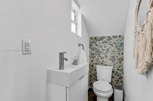 a bathroom with a toilet sink and mirror