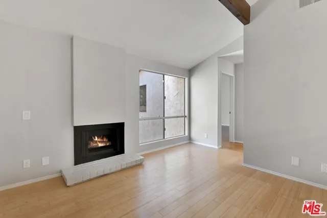 a view of an empty room with a fireplace and window