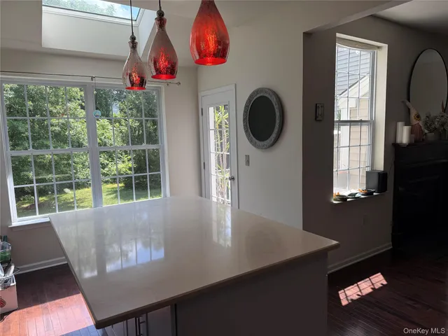 a kitchen with stainless steel appliances a sink a stove a refrigerator cabinets and wooden floor