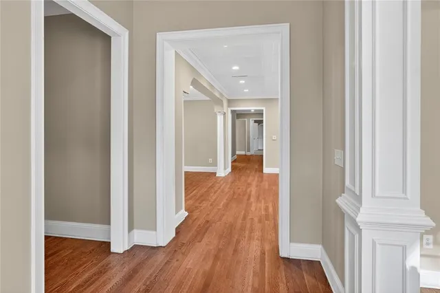 a kitchen with a sink a stove a refrigerator and white cabinets with wooden floor