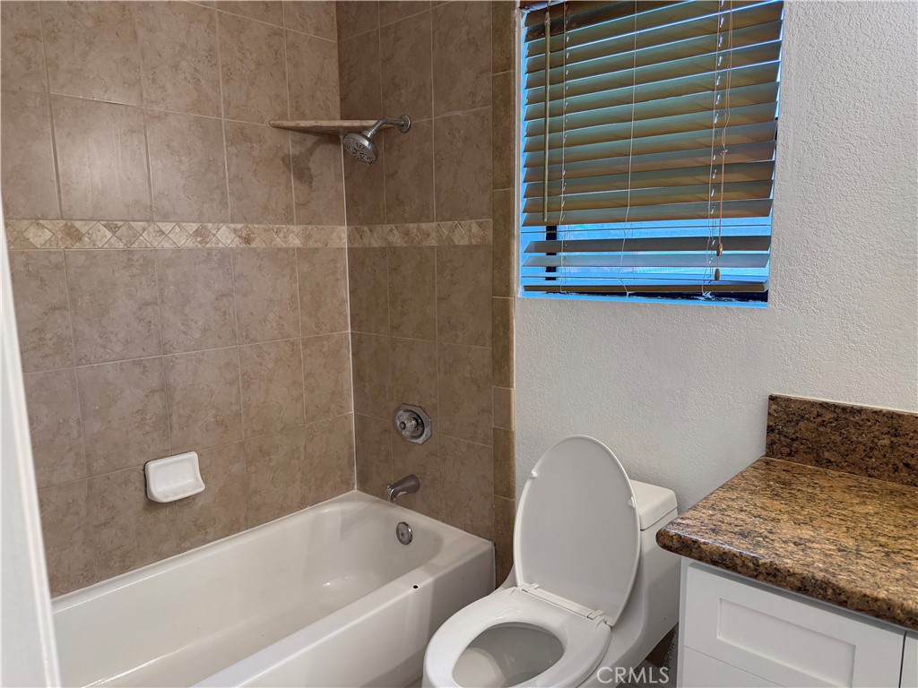 2421 Mangular Avenue Corona, CA 92882 - Photo 16 of 25 a bathroom with a granite countertop sink toilet and bathtub