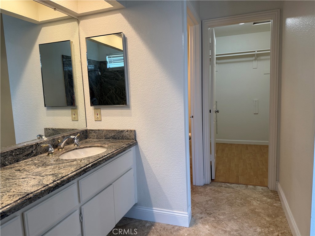 2421 Mangular Avenue Corona, CA 92882 - Photo 21 of 25 a bathroom with a granite countertop sink and a mirror