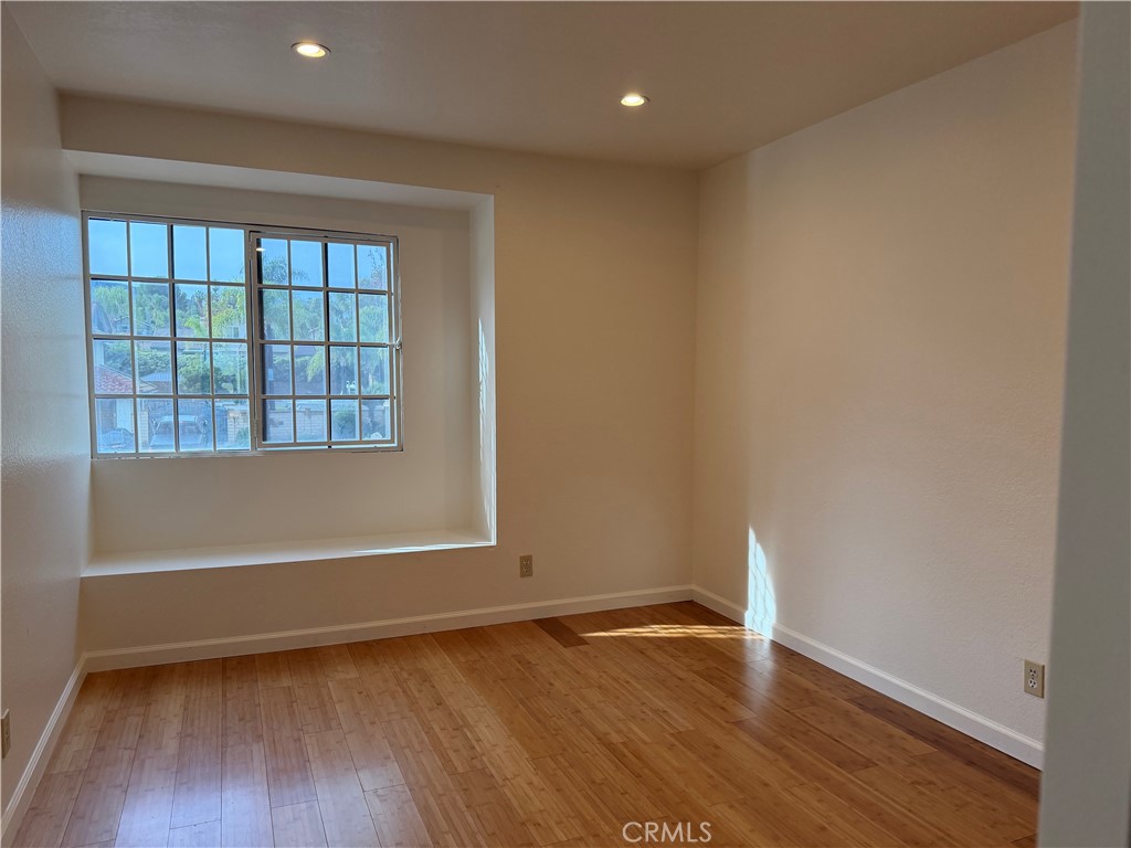 2421 Mangular Avenue Corona, CA 92882 - Photo 24 of 25 a view of an empty room with wooden floor and a window