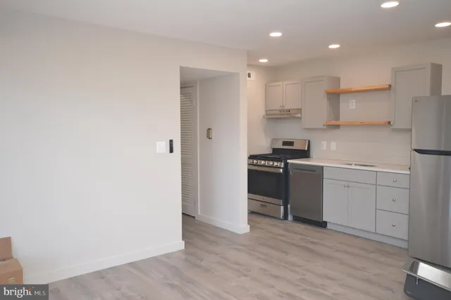 a kitchen with a refrigerator and white cabinets