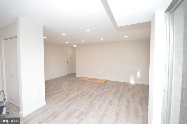 a view of an empty room with wooden floor