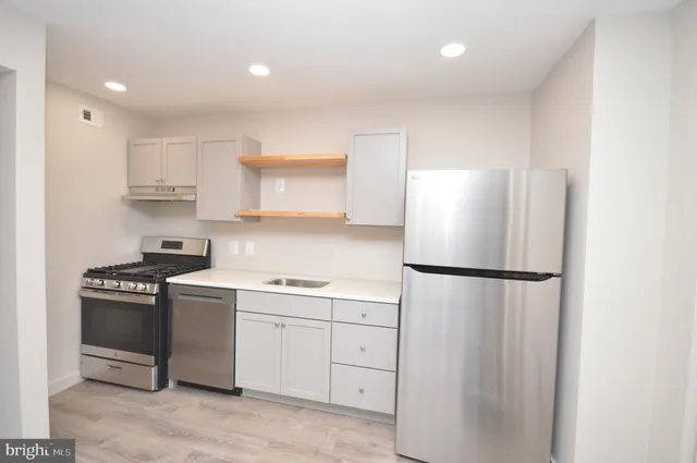 a kitchen with white cabinets and white appliances