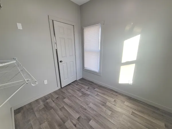 a view of empty room with window and wooden floor