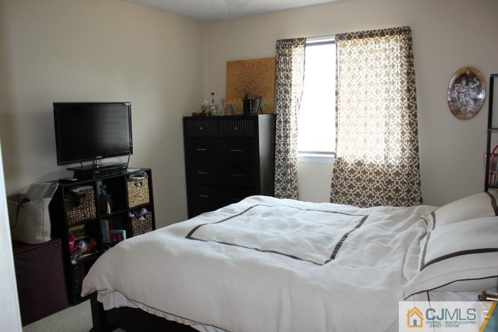 5205 Hana Road Edison, NJ 08817 - Photo 12 of 15 a bedroom with a bed and a flat screen tv