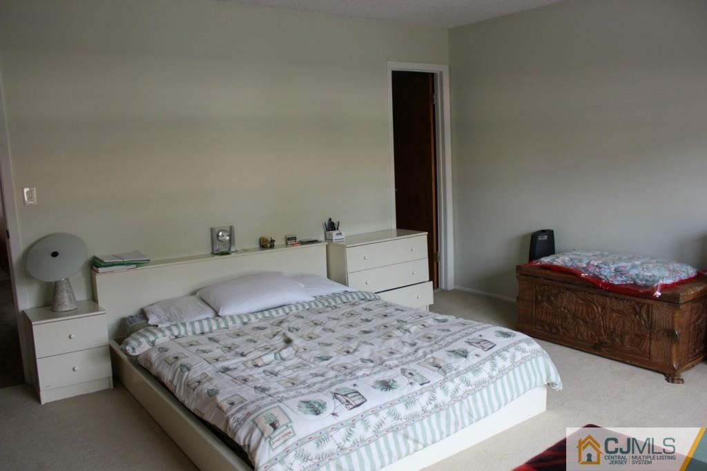 5205 Hana Road Edison, NJ 08817 - Photo 10 of 15 a bedroom with a bed and a table