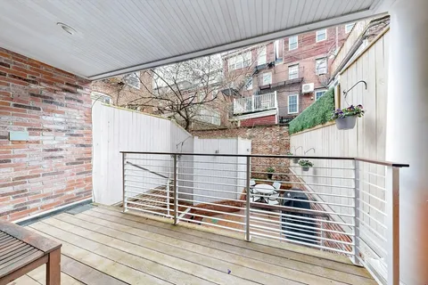 a view of a balcony with wooden floor and fence and a floor to ceiling window