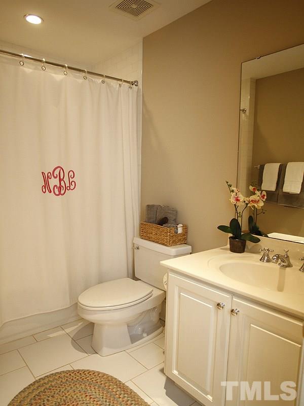 1307 Duplin Road Raleigh, NC 27607 - Photo 14 of 19 a bathroom with a sink a toilet and a mirror