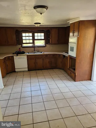 a large kitchen with a stove a bathtub and a sink