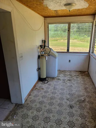 a view of an empty room with a fireplace and a window