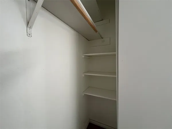 a view of walk in closet with empty racks