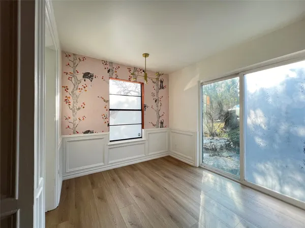 a view of a big room with wooden floor and windows