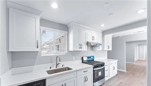 a kitchen with stainless steel appliances granite countertop a sink stove and cabinets