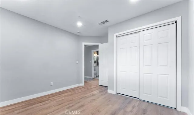 an empty room with wooden floor and closet