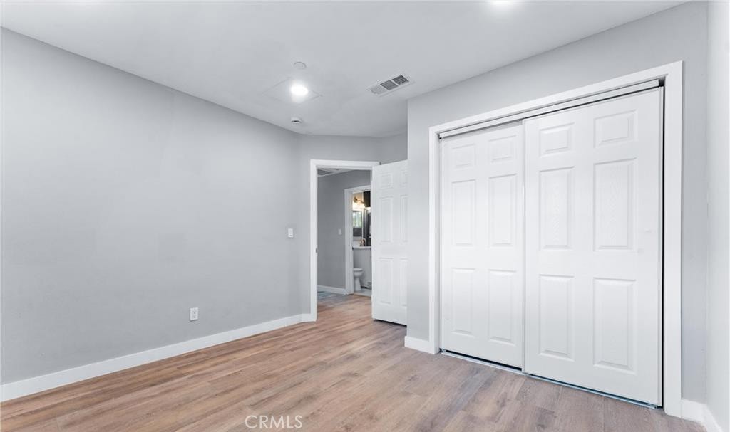 1531 West Orange Grove Avenue Pomona, CA 91768 - Photo 10 of 16 an empty room with wooden floor and closet
