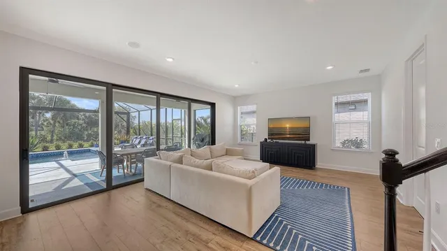 a living room with furniture wooden floor and a flat screen tv