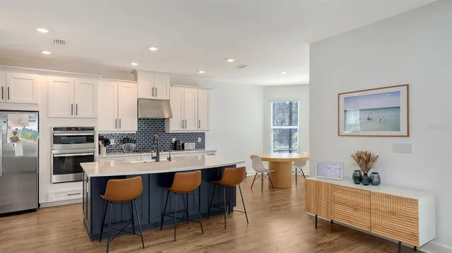 a large kitchen with kitchen island a sink stainless steel appliances and cabinets