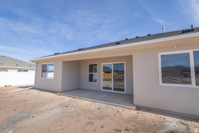 910 East Remington Road Cedar City, UT 84721 - Photo 29 of 29 Rear exterior featuring a covered patio, sliding glass doors, white frame windows, and an asphalt shingle roof