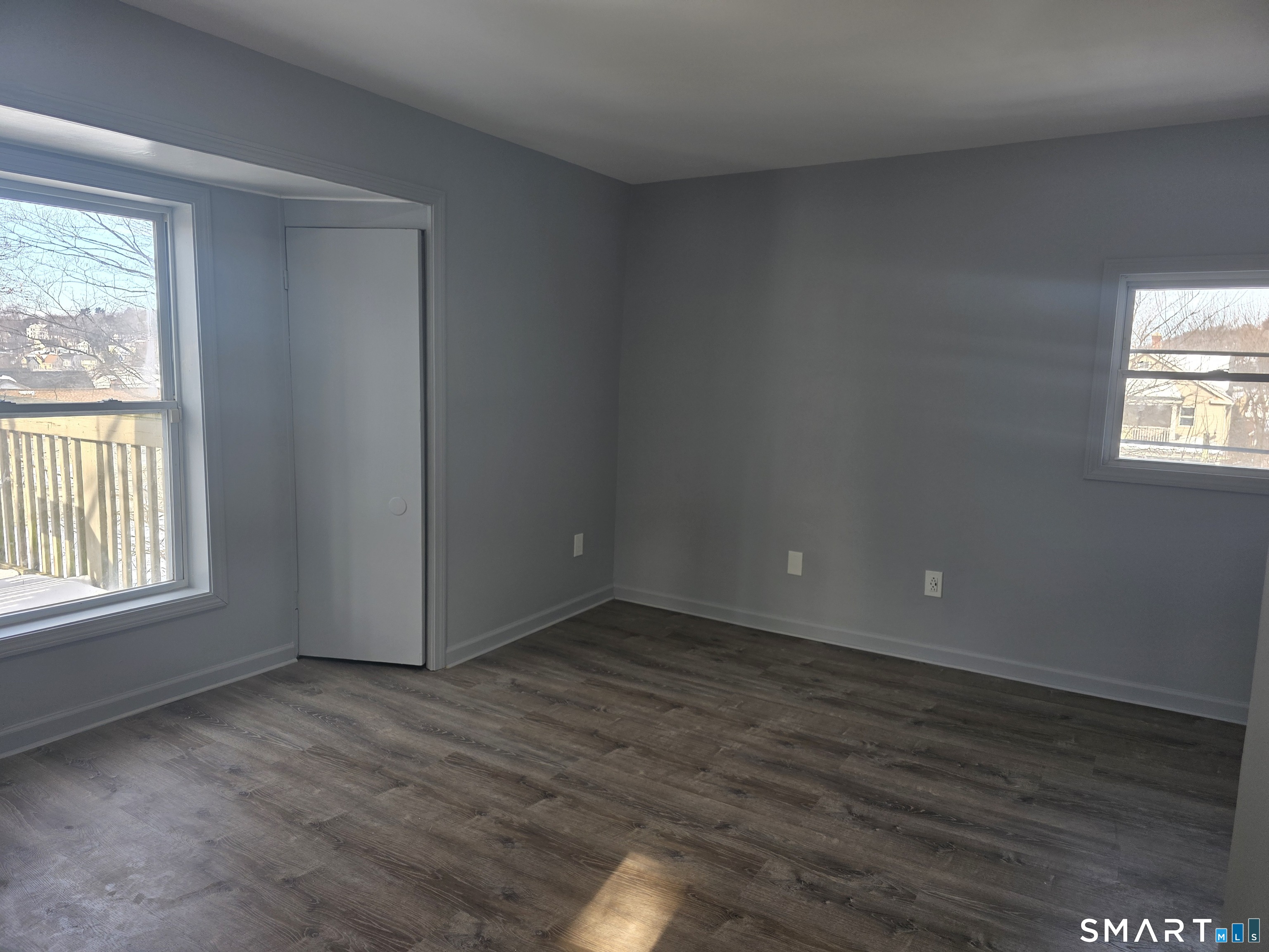 46 Ward Street Waterbury, CT 06704 - Photo 7 of 9 an empty room with wooden floor and windows