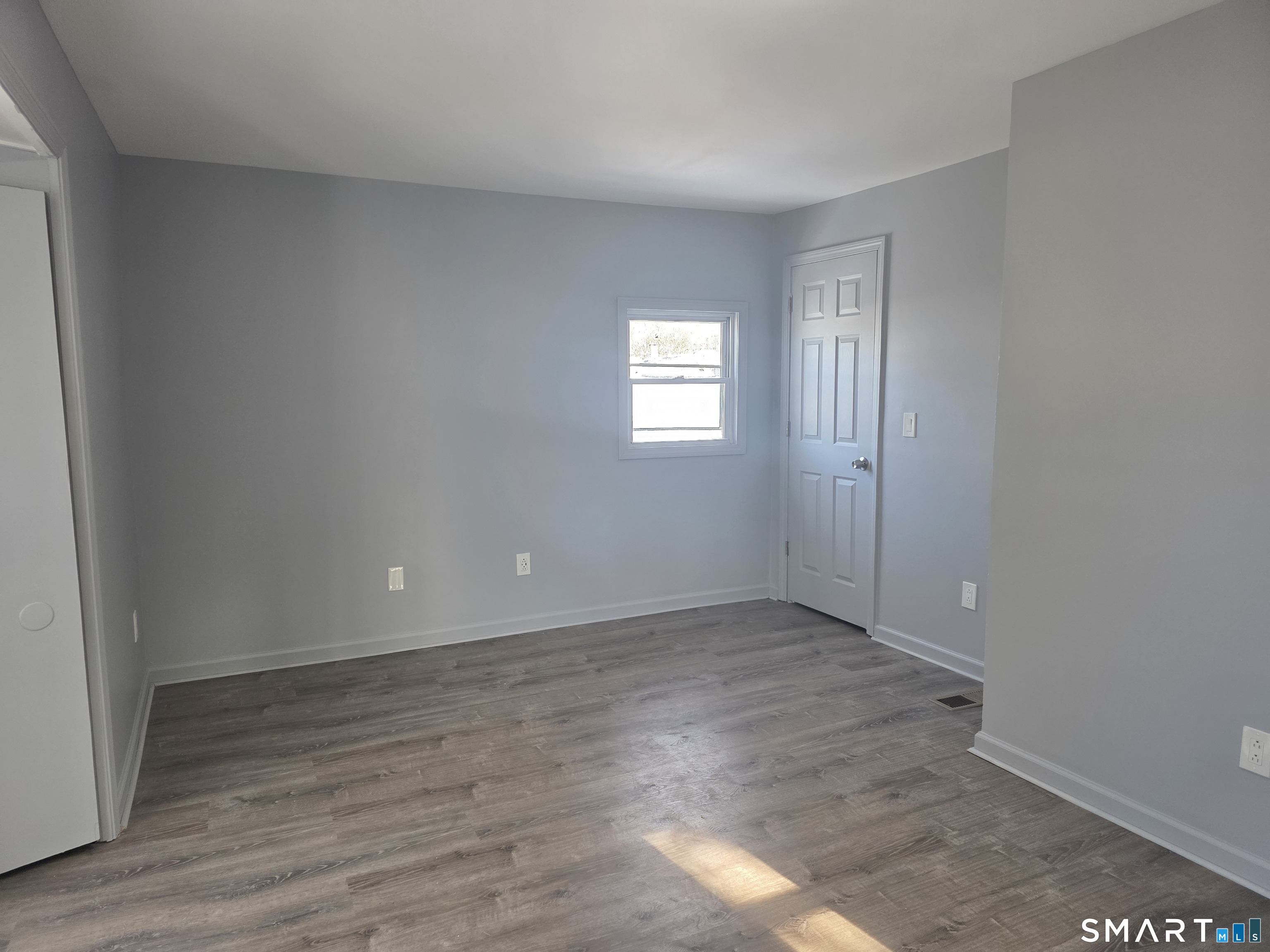 46 Ward Street Waterbury, CT 06704 - Photo 9 of 9 an empty room with wooden floor and windows