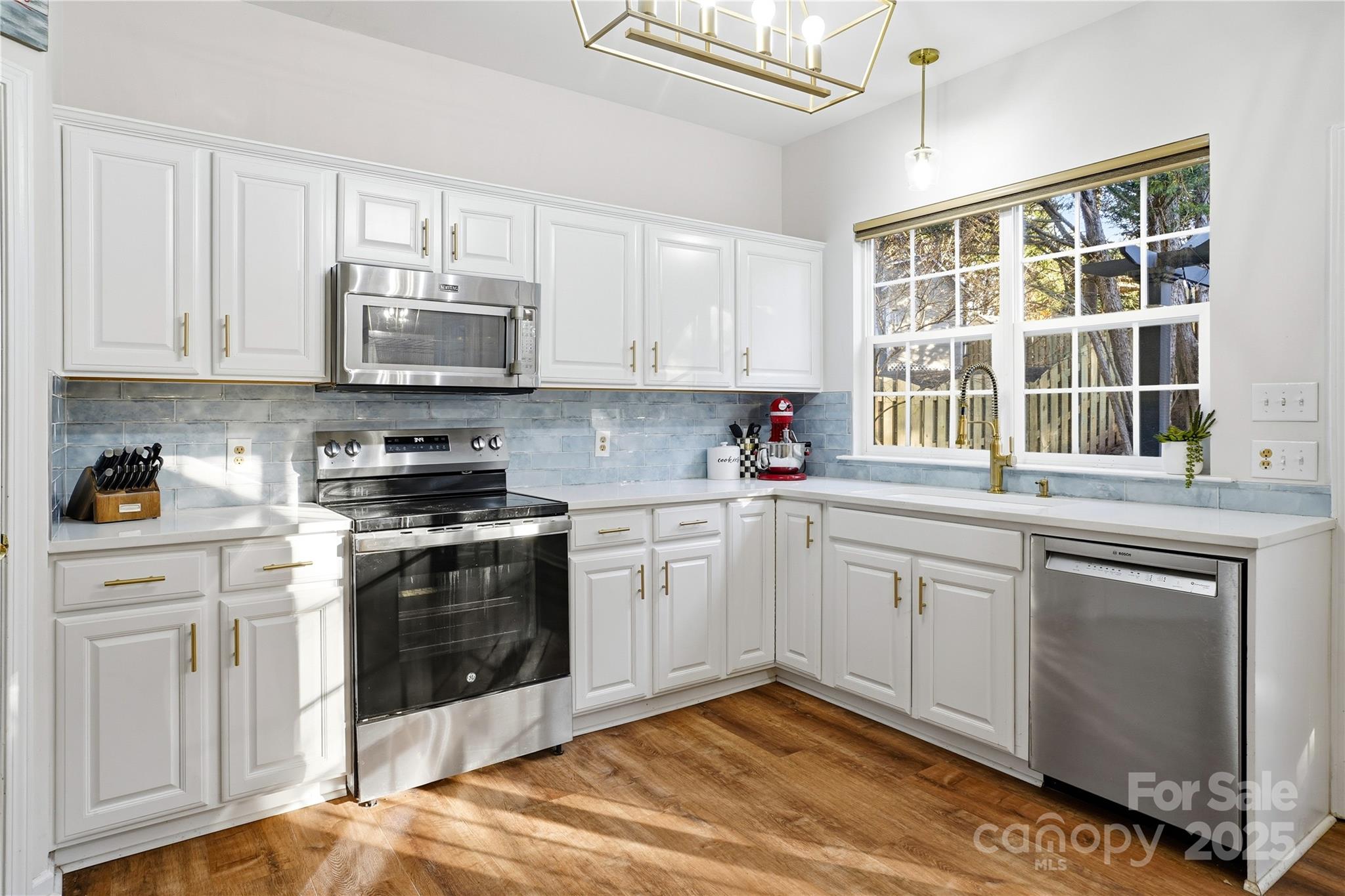 18015 Harbor Mist Road Cornelius, NC 28031 - Photo 11 of 37 a kitchen with stainless steel appliances granite countertop a stove a sink and a microwave