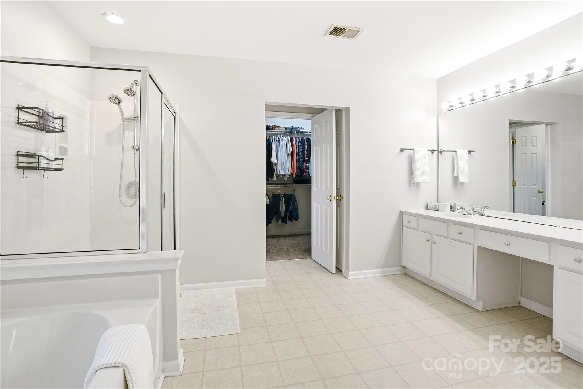 18015 Harbor Mist Road Cornelius, NC 28031 - Photo 20 of 37 a bathroom with a double vanity sink a large mirror and shower