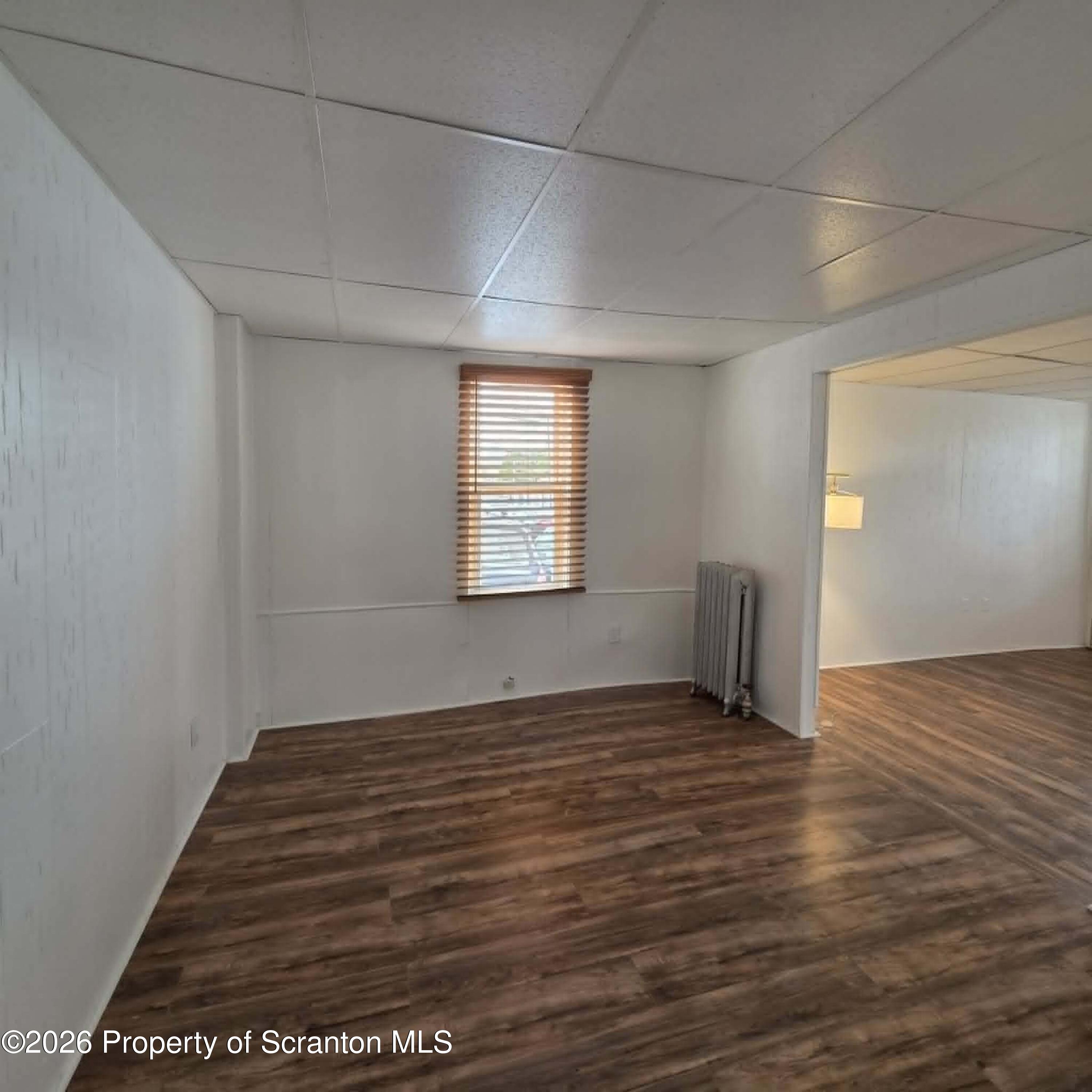 1606 Dickson Avenue, Unit 1 Scranton, PA 18509 - Photo 4 of 16 a view of an empty room with wooden floor and a window
