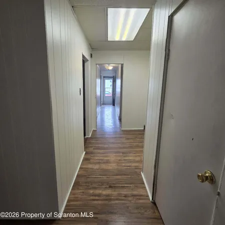 a view of a hallway with wooden floor