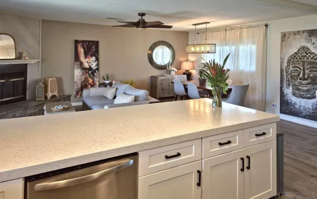 a kitchen with kitchen island a stove a sink and a dining table with wooden cabinet