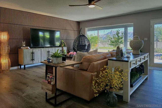 a living room with furniture a chandelier and a wooden floor