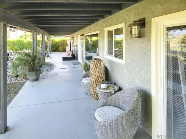 a living room with patio furniture and a large window