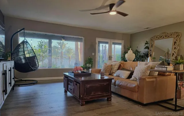 a living room with furniture and a painting on the wall