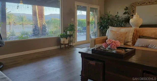 a living room with furniture a flat screen tv and a floor to ceiling window