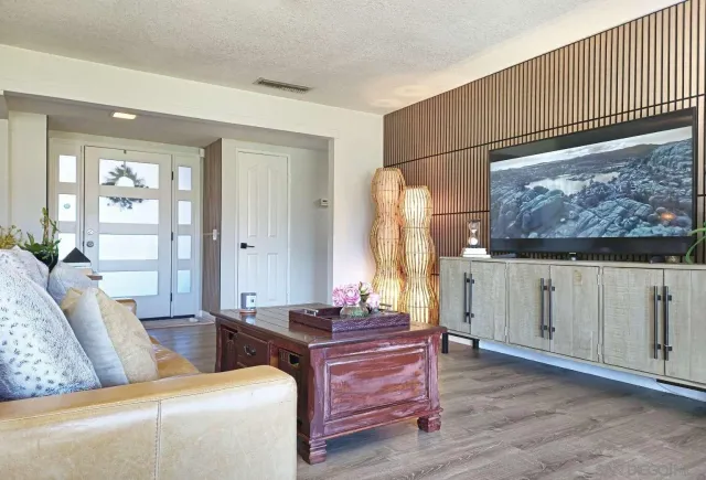 a living room with furniture a large window and dresser