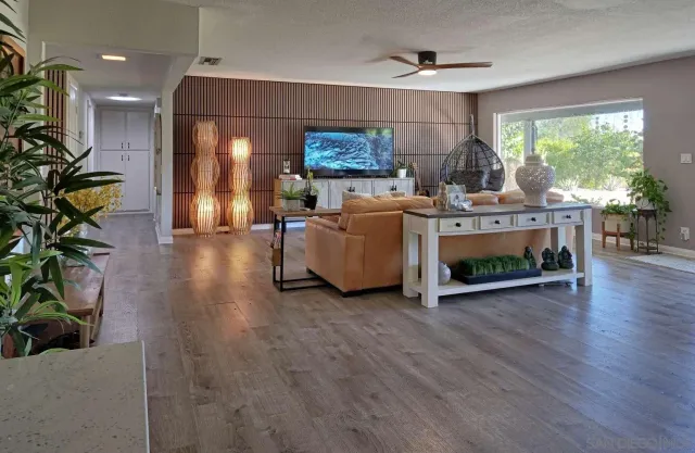a living room with furniture a chandelier and a wooden floor